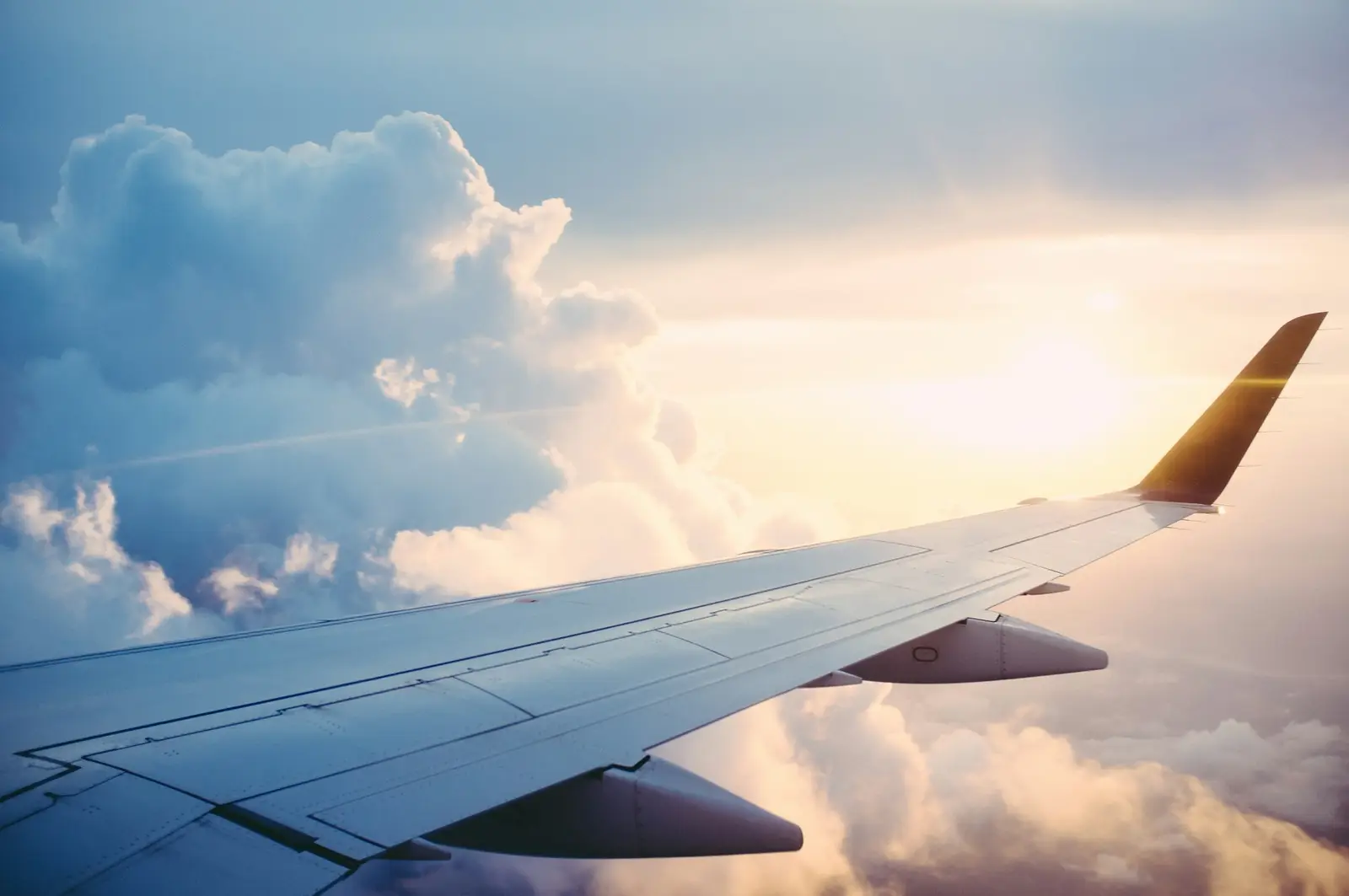 Aile d'un Airbus au-dessus des nuages au lever du soleil